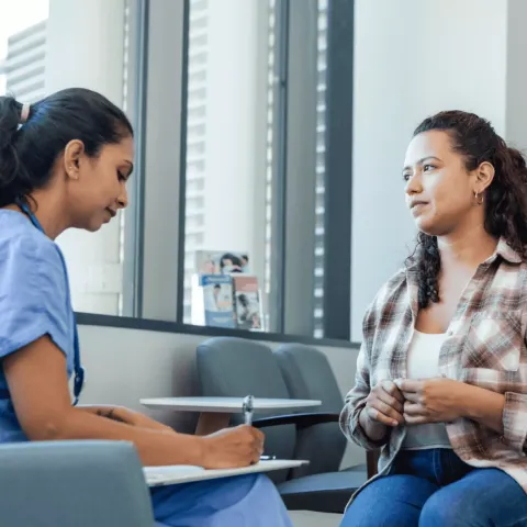 Woman talking with Doctor at Hospital.
