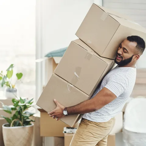 Man holding a large stock of boxes.