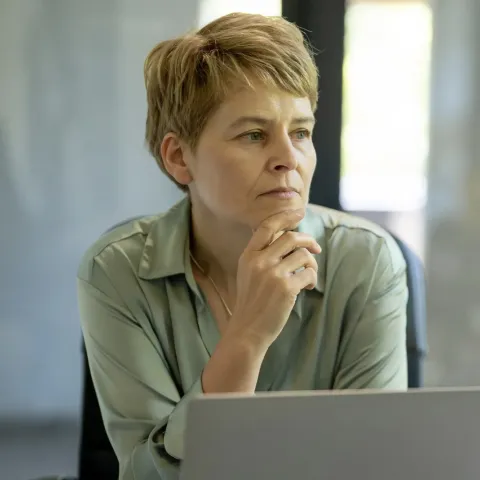 Woman looking pensively near her computer.