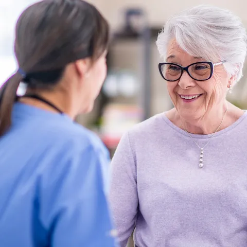 An elderly woman talking to a nurse.