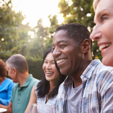 Friends sitting outdoors at a table during a dinner party.