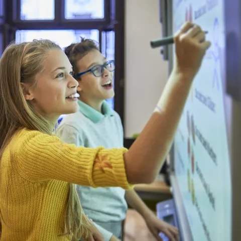 Two Middle School Kids Writing on Board