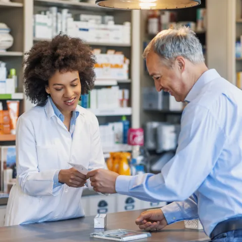 Pharmacist helping customer with filling prescription.