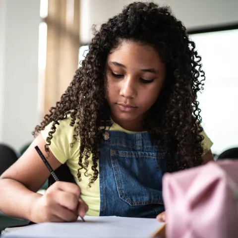African American Girl Writing in Notebook
