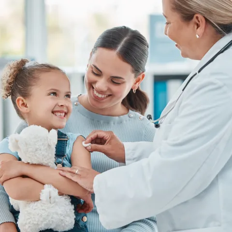 Doctor giving little girl a vaccine shot