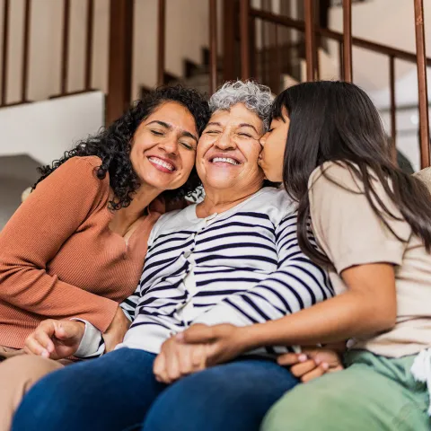 A multi-generational family sitting on the couch together.