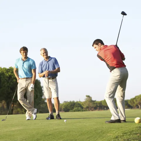 Three men golfing.