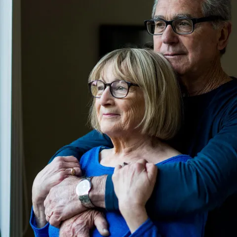 Older Couple Comforting Each Other Looking Outside