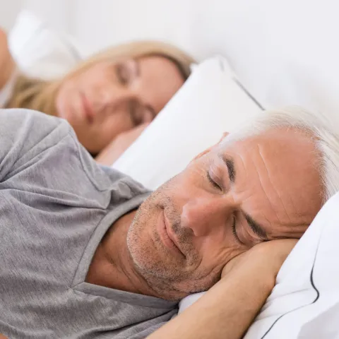 Mature couple sleeping on their bed