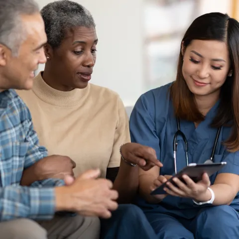 An older couple reviews their test results with their doctor.