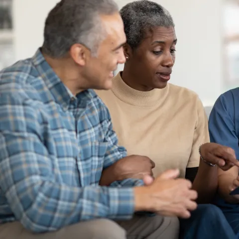 An older couple reviews their test results with their doctor.