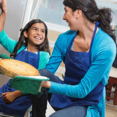 A family bakes a pie together.