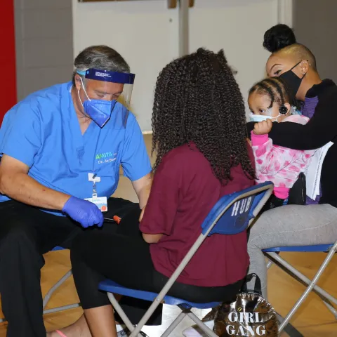 Dr. de Ramos doing clinical care on a child