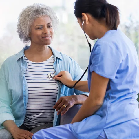 Female Doctor Listening to Female Patient's Heart