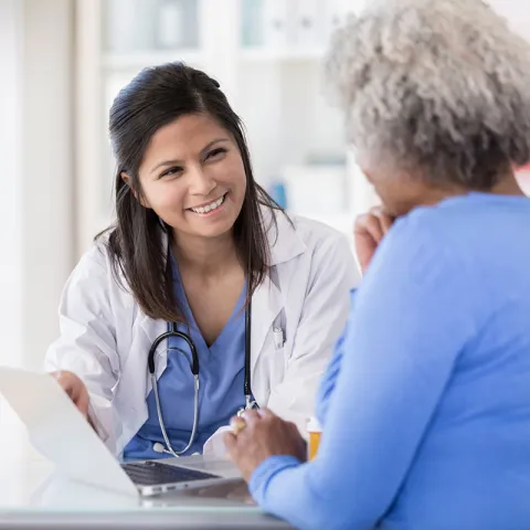 Neurosurgeon Doctor Talking to Patient and Showing Brain Scans