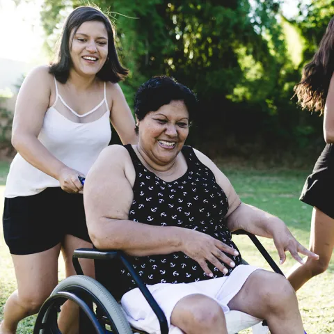 Woman in wheelchair with daughters outside 