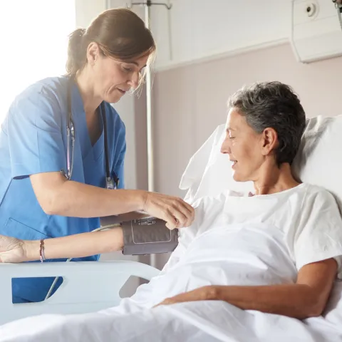 Nurse and patient in hospital room.