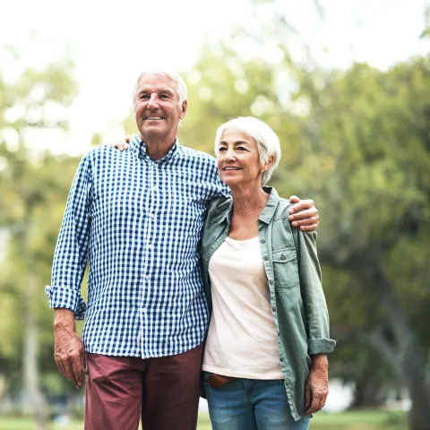 A man and woman embracing in the outdoors.