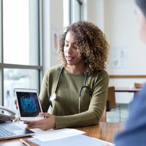 A patient and physician looking at a laptop screen