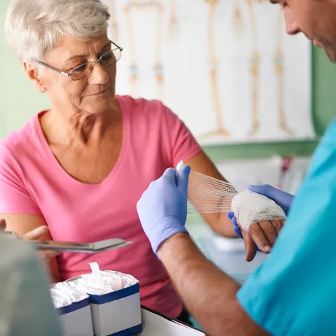 Older Woman Getting Bandage Wrapped on Wound