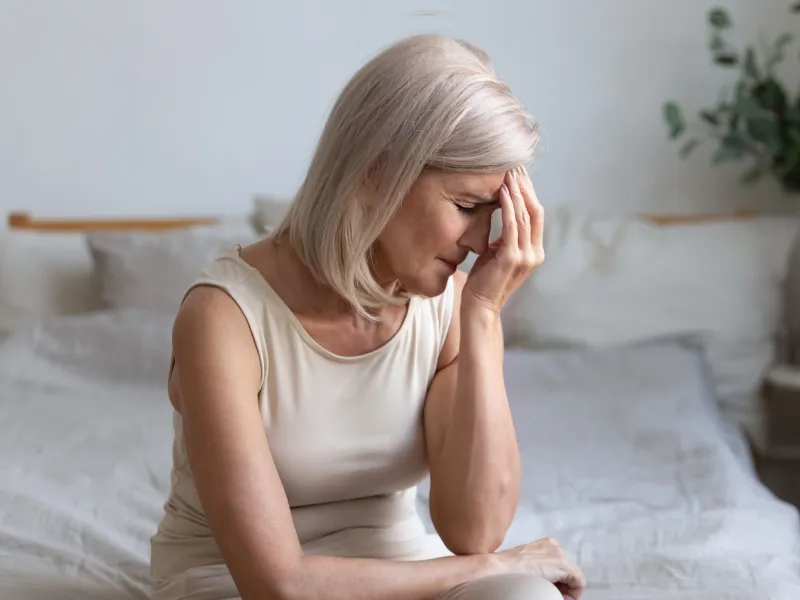 Senior Woman rubbing forehead in pain