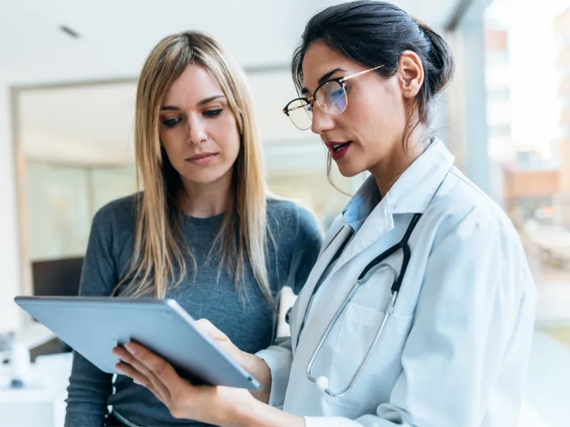 Female Patient Looking at Tablet With Female Doctor