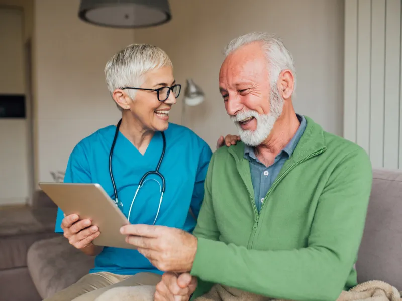 A Nurse Smiles as She Goes Over a Patient's Chart with Him