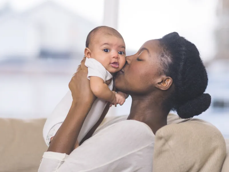 Mother Holding and Kissing Baby
