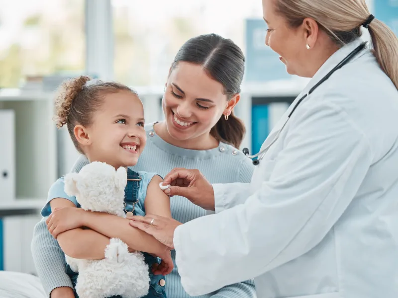 Doctor giving little girl a vaccine shot