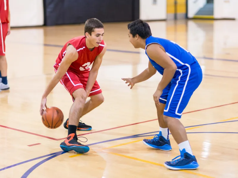 Two Teens Playing Indoor Basketball