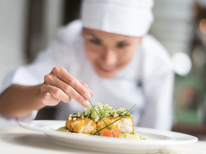 Woman Chef Garnishing Plate of Food