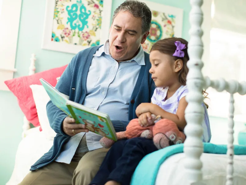 Grandpa Reading to Little Girl