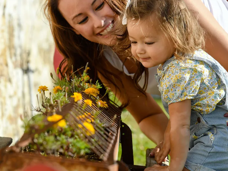 Mother and daughter smelling flowers. 