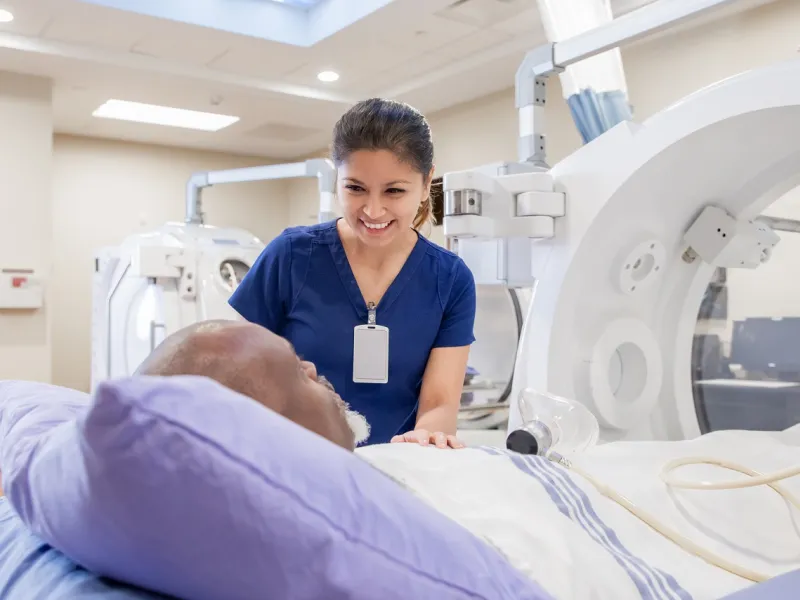 Nurse prepping patient for treatment in Hyperbaric Chamber
