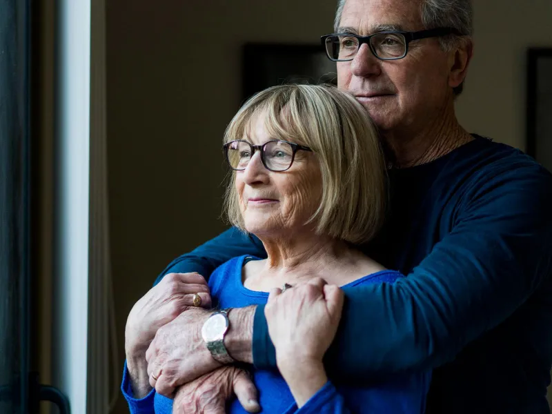 Older Couple Comforting Each Other Looking Outside