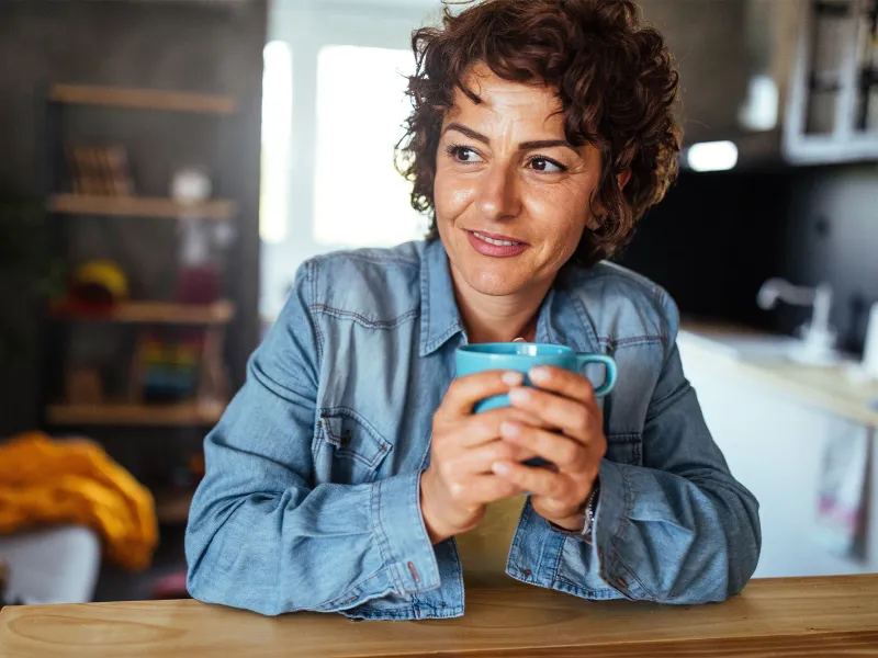 Woman holding cup of tea in living room
