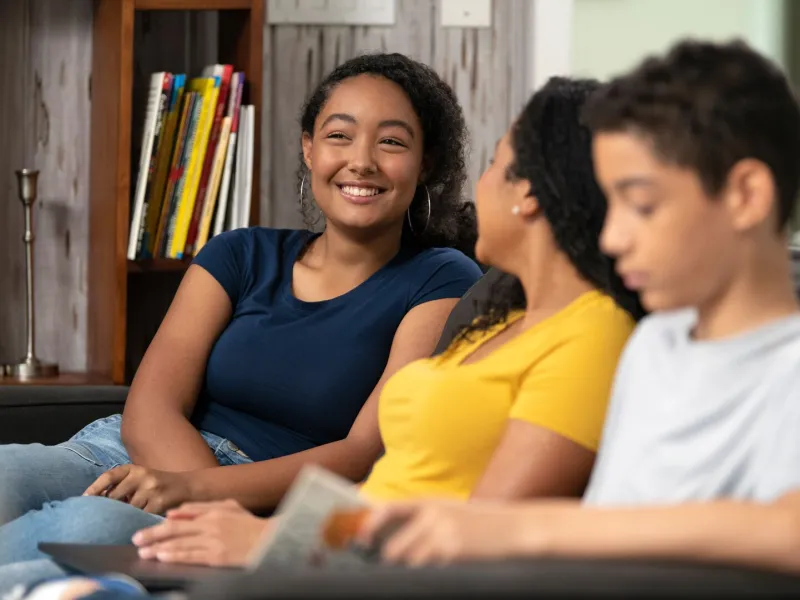 Teenage Girl Spending Time With Mom and Brother on Couch