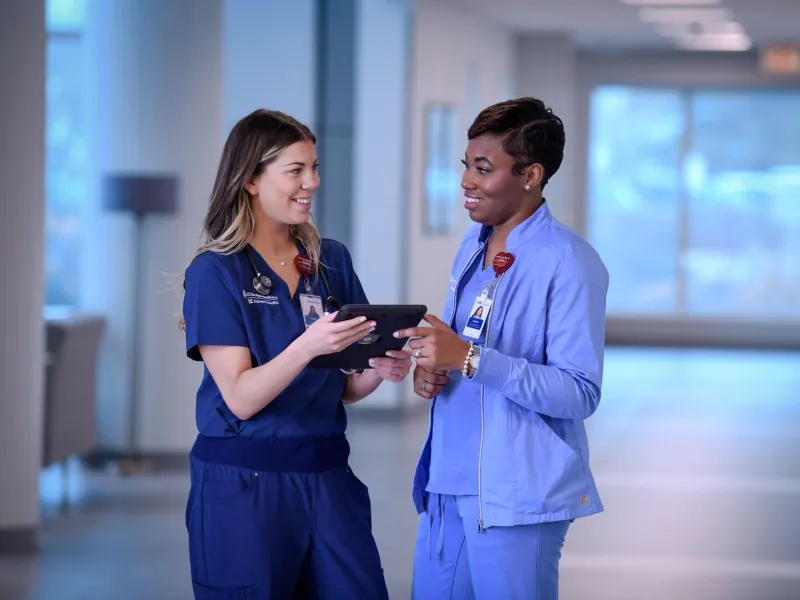 Nurses Looking at Each Other Holding Tablet
