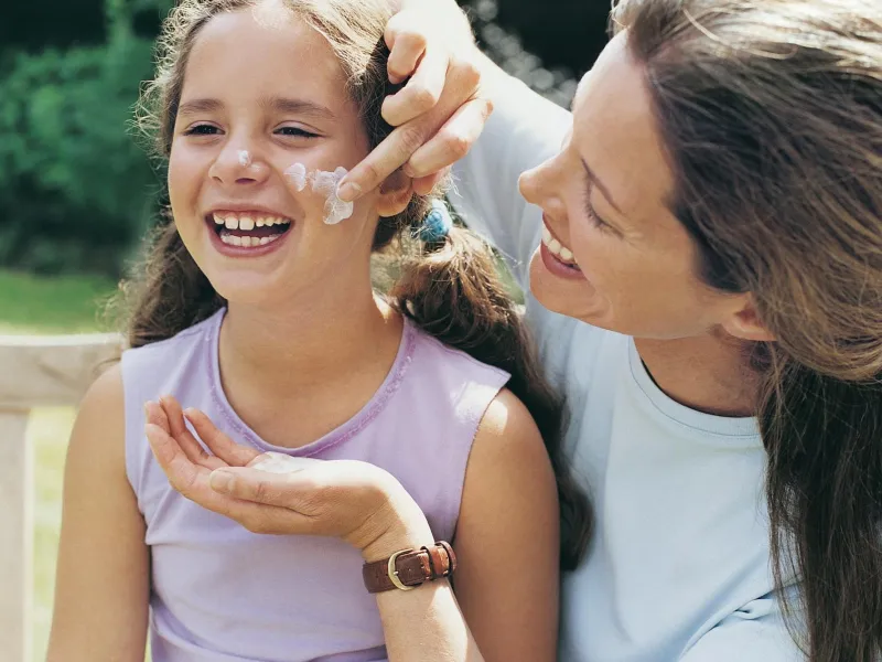 Mom applying sunscreen to daughter