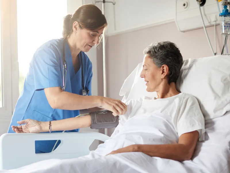 Nurse and patient in hospital room.
