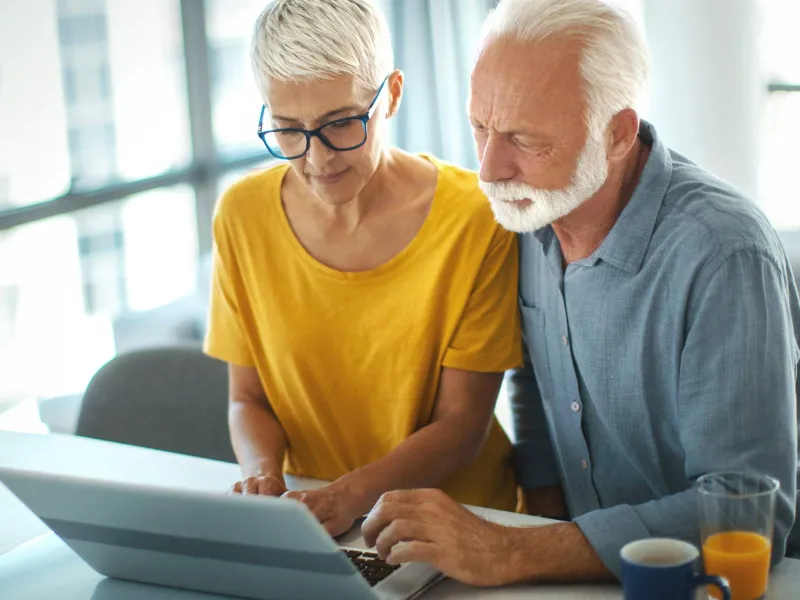 Older couple looking at computer screen in living room