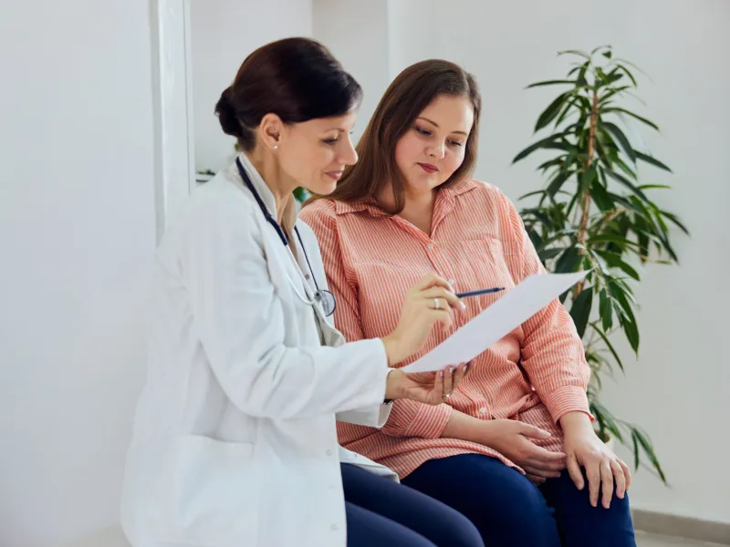 A woman and her healthcare provider looking at a document together.