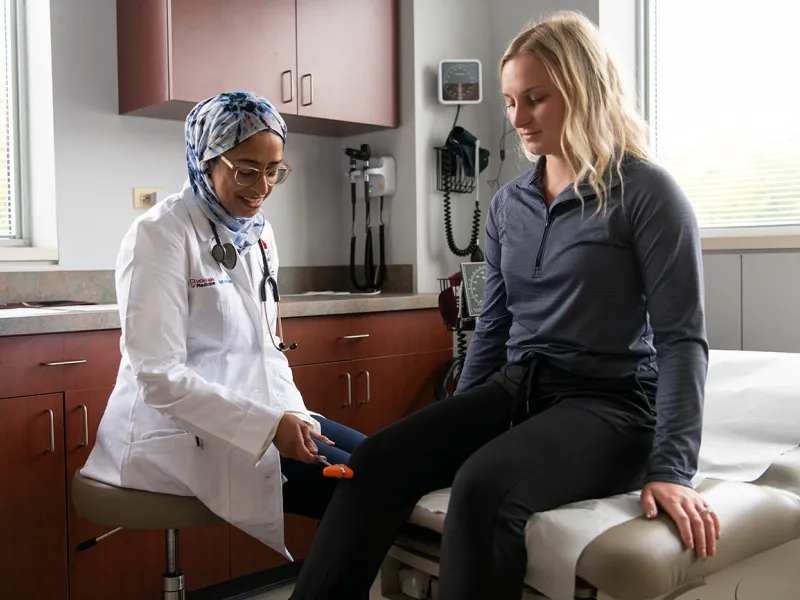 Doctor with patient checking knee functionality