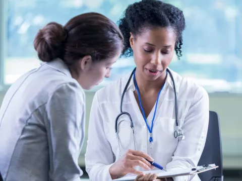 A Physician Goes Over A Chart With Her Patient 