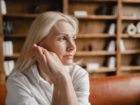 A Woman Thinks Deeply with Her Hand Pressed Against Her Face