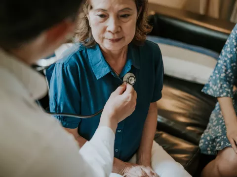 A Doctor Checks the Breathing of a Female Patient With a Stethoscope in an Office