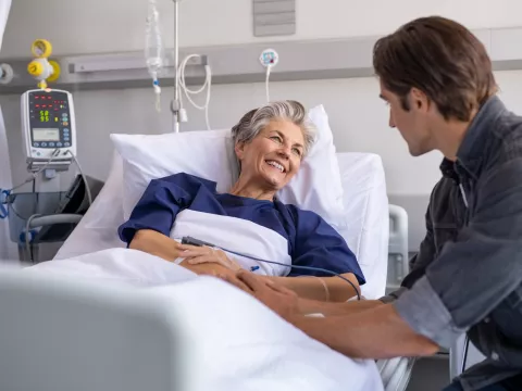 Son visiting sick old mother in hospital