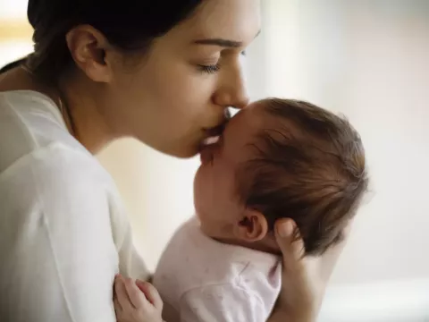 Mother Kissing Baby on Forehead