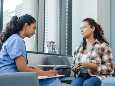 Woman talking with Doctor at Hospital.