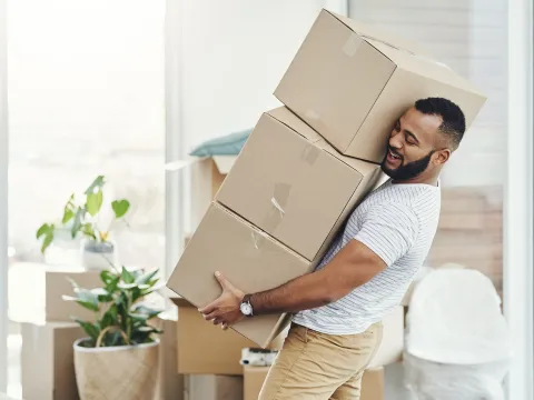 Man holding a large stock of boxes.